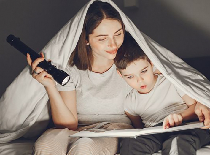 mother_and_son_under_the_blanket_in_bed_reading_a_book_650x41.jpg